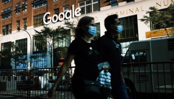 Masked people walk past Google offices in New York City.