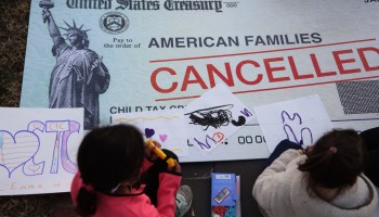 Children draw on a canceled check prop during a rally at the U.S. Capitol this week.