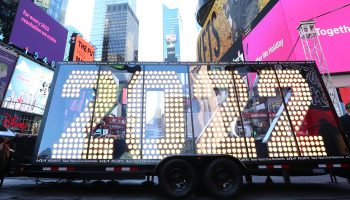 In Times Square, a central light display on wheels shows the numbers "2022."
