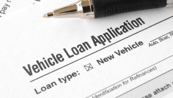 A pen sits atop a vehicle loan application.