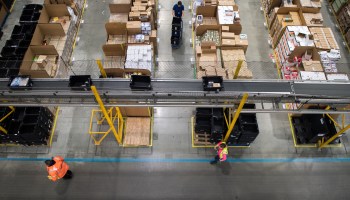 Workers prepare customer orders for dispatch as they work around goods stored inside an Amazon fulfillment center in November 2017.