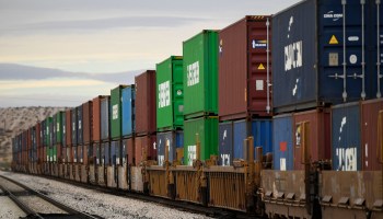 A freight train carries cargo shipping containers along the U.S.-Mexico border.