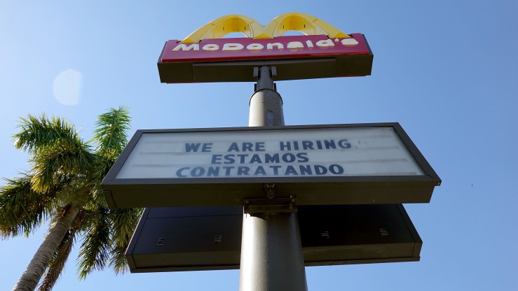 A We Are Hiring sign hangs in front of a McDonald's restaurant on December 03, 2021 in Miami, Florida.