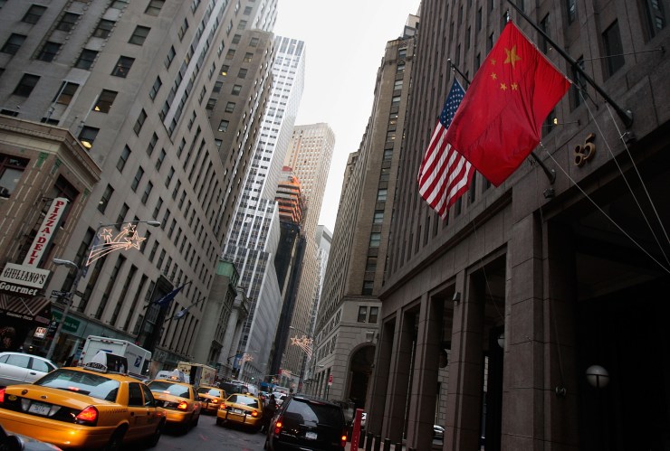 The flag of the People's Republic of China hangs next to an American flag outside the Goldman Sachs headquarters building in New York.