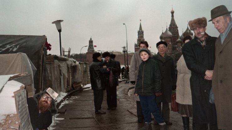 Soviet citizens pass by homeless and hunger strikers sheltered in self-made tents in a square of Moscow, on December 3, 1990.