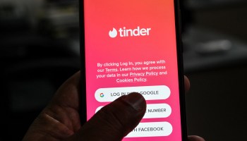 In this photo illustration taken on October 6, 2020, a user checks the dating app Tinder on a mobile phone.