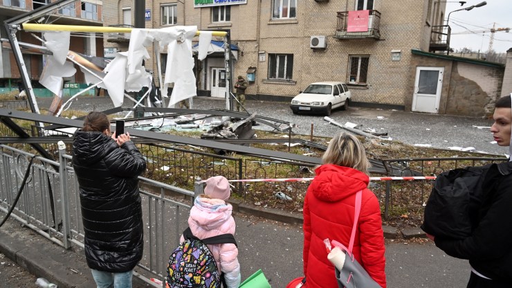 People look at the remains of a shell in Kyiv.
