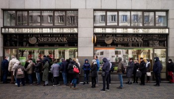 People queue outside a branch of Russian state-owned bank Sberbank to withdraw their savings and close their accounts in Prague on February 25, 2022, before Sberbank will close all its branches in the Czech Republic later in the day. - US President Biden was the first to announce sanctions, hours after Russian President Putin declared a "military operation" into Ukraine. The first tranche will hit four Russian banks -- including the country's two largest, Sberbank and VTB Bank -- cut off more than half of Russia's technology imports, and target several of the country's oligarchs. (Photo by Michal Cizek / AFP) (Photo by MICHAL CIZEK/AFP via Getty Images)