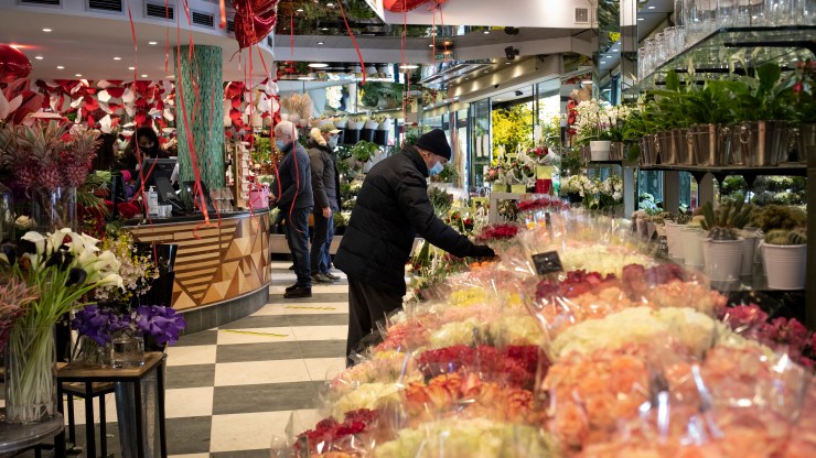 Customers buy flowers at a florist prior to Valentine's Day celebrations on February 13, 2021 in Paris, France.