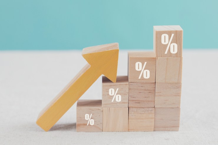 A photo illustration shows building blocks stacked on top of each other in the shape of a staircase, while an arrow points up along the slope of that staircase to signal an increasing trend line.