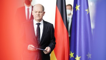German Chancellor Olaf Scholz stands next to the German and European Union flags on Feb. 24 in Berlin.