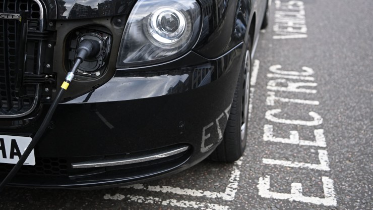 A charging cable is pictured plugged into an LEVC (London Electric Vehicle Company) eCity taxi in London on November 18, 2020.