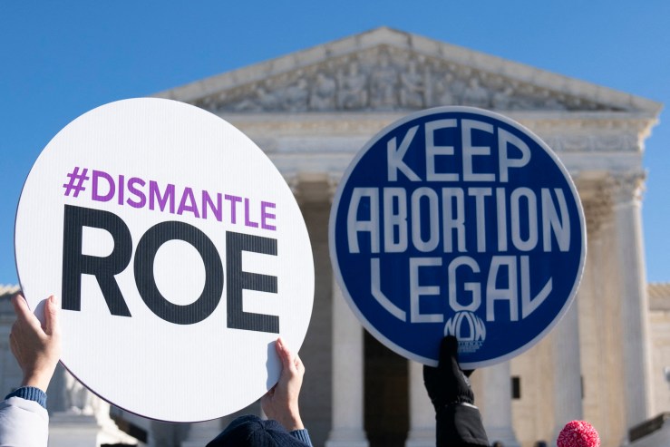 Pro-abortion and anti-abortion activists hold protest signs outside the US Supreme Court