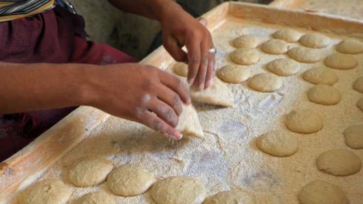 worker preparing bread at a bakery in Yemen