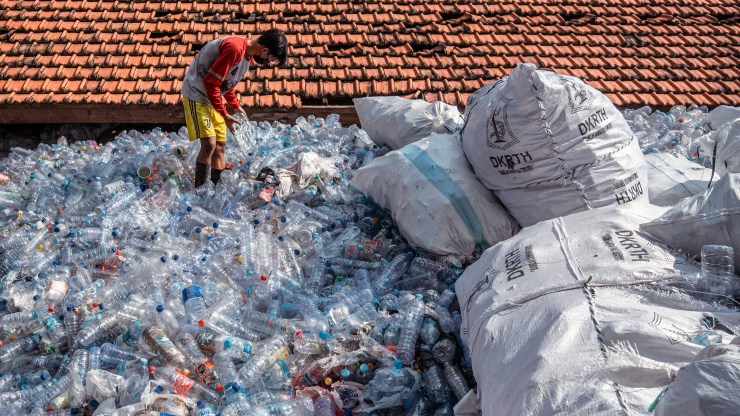 A worker sorts and packs used plastic bottles and bottle caps collected in exchange for city bus tickets in Surabaya on March 3, 2022.