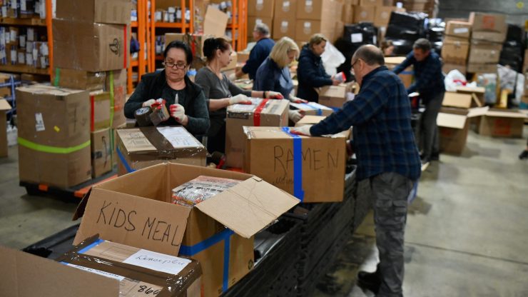 People packing boxes of aid items to send in support of Ukraine.