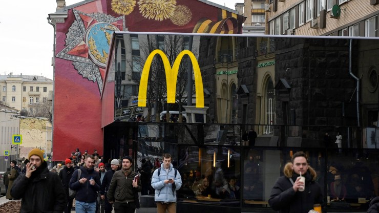 Men walk in front of the McDonald's flagship restaurant at Pushkinskaya Square - the first one of the chain opened in the USSR on January 31, 1990 - in central Moscow on March 13, 2022, McDonald's last day in Russia.