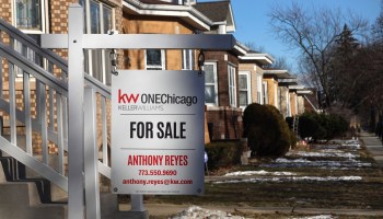 A for sale sign is seen in a row of Chicago homes.