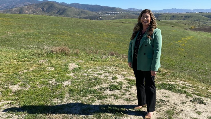 Miranda Evans, special projects manager for the city of Chula Vista, smiles in a wide-open green space.