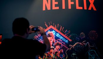 A visitor takes a picture at the stand of Netflix during the Video games trade fair Gamescom in Cologne, western Germany