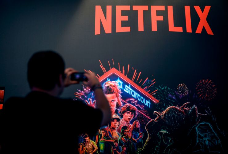 A visitor takes a picture at the stand of Netflix during the Video games trade fair Gamescom in Cologne, western Germany