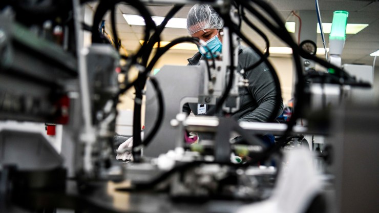 Employees work as they make respiratory masks in a family-owned medical equipment factory in north Miami, Florida on February 15, 2021.