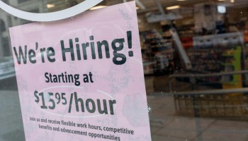 A We're Hiring sign is displayed in the window of a store in Washington, DC, on February 2, 2022. -