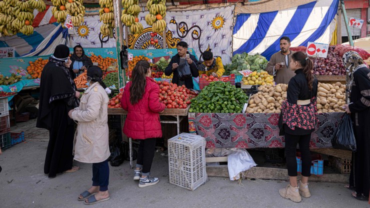 People shop at a stall in a public market in el-Arish city, in the northern Sinai Peninsula, on March 20, 2022.