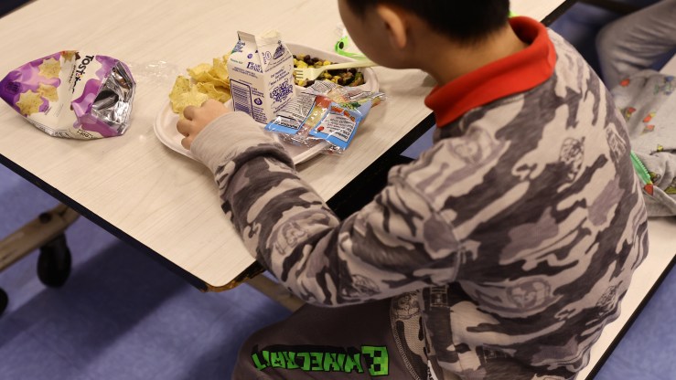 A student eats a vegan lunch with milk at a New York elementary school.
