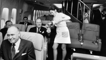 A Pan American (Pan Am) airhostess serving champagne in the first class cabin of a Boeing 747 jumbo jet. (Photo by Tim Graham/Getty Images)