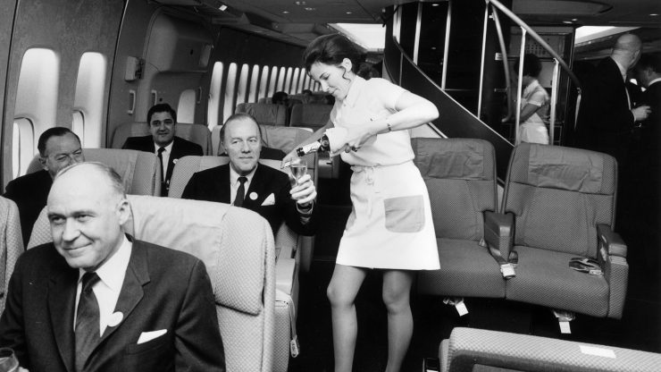A Pan American (Pan Am) airhostess serving champagne in the first class cabin of a Boeing 747 jumbo jet. (Photo by Tim Graham/Getty Images)