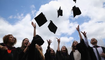 Students throw their caps in the air at a graduation ceremony at the Royal Festival Hall in London, England.