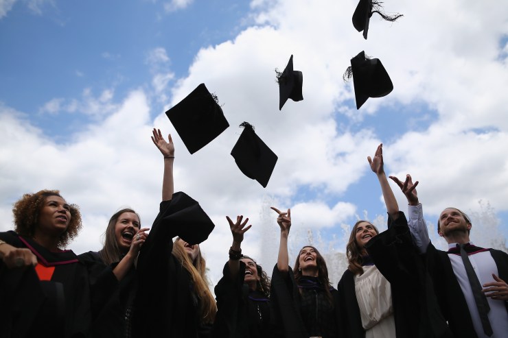Students throw their caps in the air at a graduation ceremony at the Royal Festival Hall in London, England.