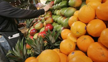 A grocer arranges mangoes in the produce section at Whole Foods January 13, 2005 in New York City.