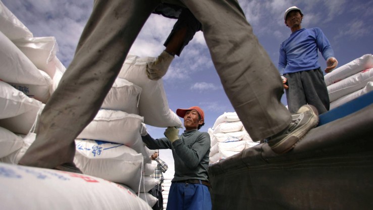 Workers load 100kg bags of potassium chloride fertilizer onto a truck at Chearhan Salt Lake Industrial Park 60km from the city of Golmud in China's northwest Qinghai province, 14 September 2005.