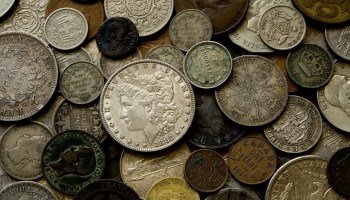 A collection of old, European coins is shown.
