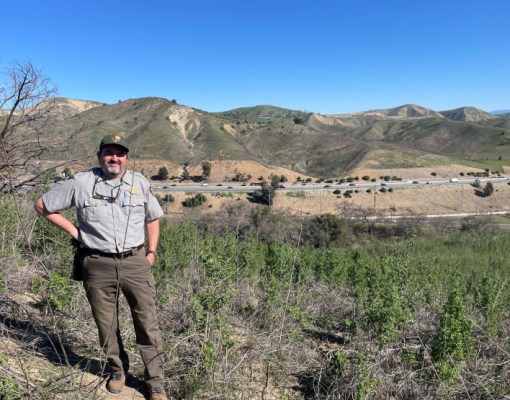 Seth Riley is tpictured here on a hill on the south side of Highway 101. In the distance, behind him, is where wildlife crossing will be located.