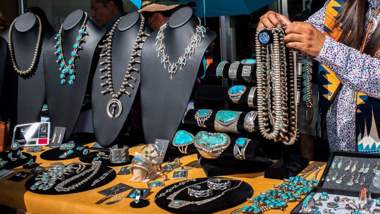 Native American man selling jewelry at a stand.