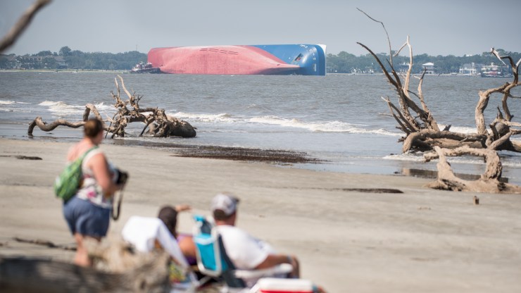 Beachgoers watch as emergency responders work to rescue crew members from the capsized Golden Ray in 2019.
