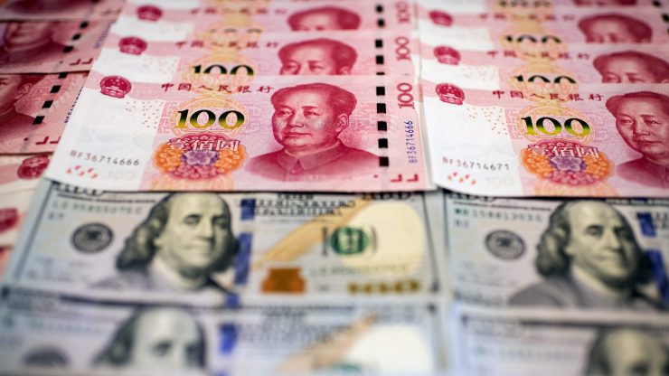 Yuan notes lined up with U.S. $100 billls.