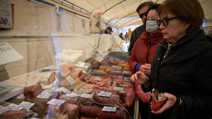 Women shopping for meat at a market in Russia.