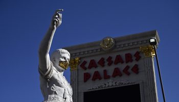 A statue of Caesar and sign that reads "Caesar's Palace" in the background over blue skies.