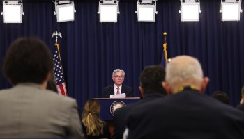 Fed Chair Jerome Powell is seen at a podium, addressing reporters at a news conference.