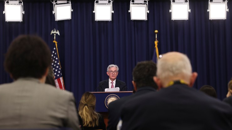 Fed Chair Jerome Powell is seen at a podium, addressing reporters at a news conference.