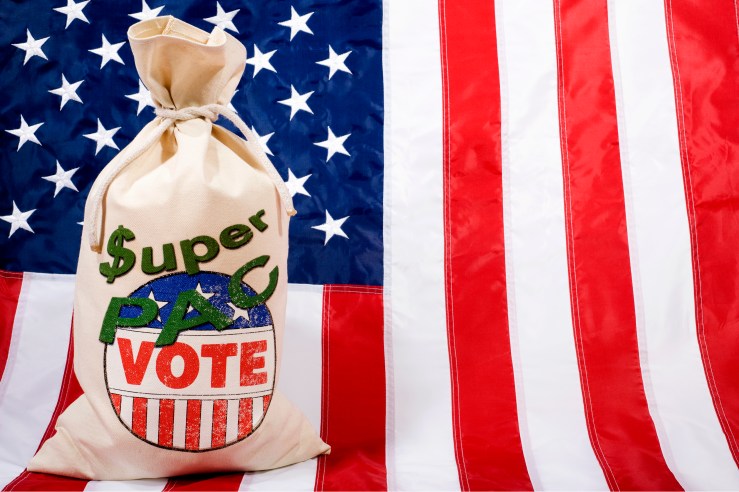 A sack of what appears to be voting ballots is stamped with the words "Super PAC" in front of the American flag.