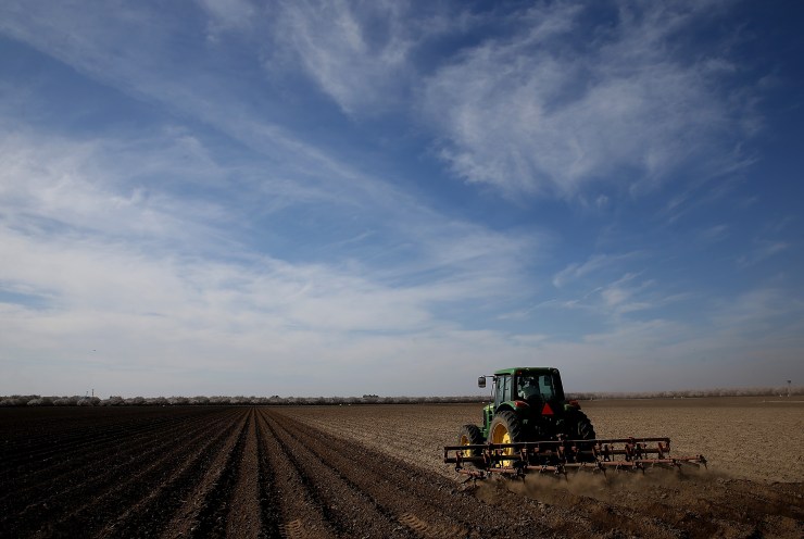 A tractor plows a field on February 25, 2014, in Firebaugh, California.