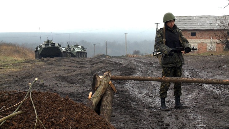 A Ukrainian soldier guards a road not far from Prokhody, a village in the Kharkiv region, some 4km from the Russian border, on April 5, 2014.