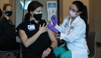 A pharmacist at Memorial Healthcare System in Florida receives the Pfizer COVID-19 vaccine.