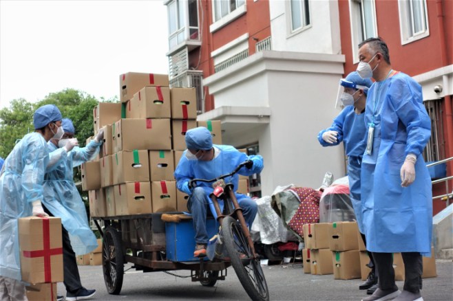 Volunteers helping to deliver handouts from a Shanghai district government. The handouts have been uneven across the financial capital where the wealthiest areas appear to have received better supplies and more than districts that are in need. (Charles Zhang/Marketplace)