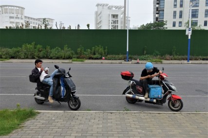 Delivery drivers resting in between orders in Shanghai. These workers often have to live on the streets to avoid lockdown measures at their apartment complexes. (Charles Zhang/Marketplace)